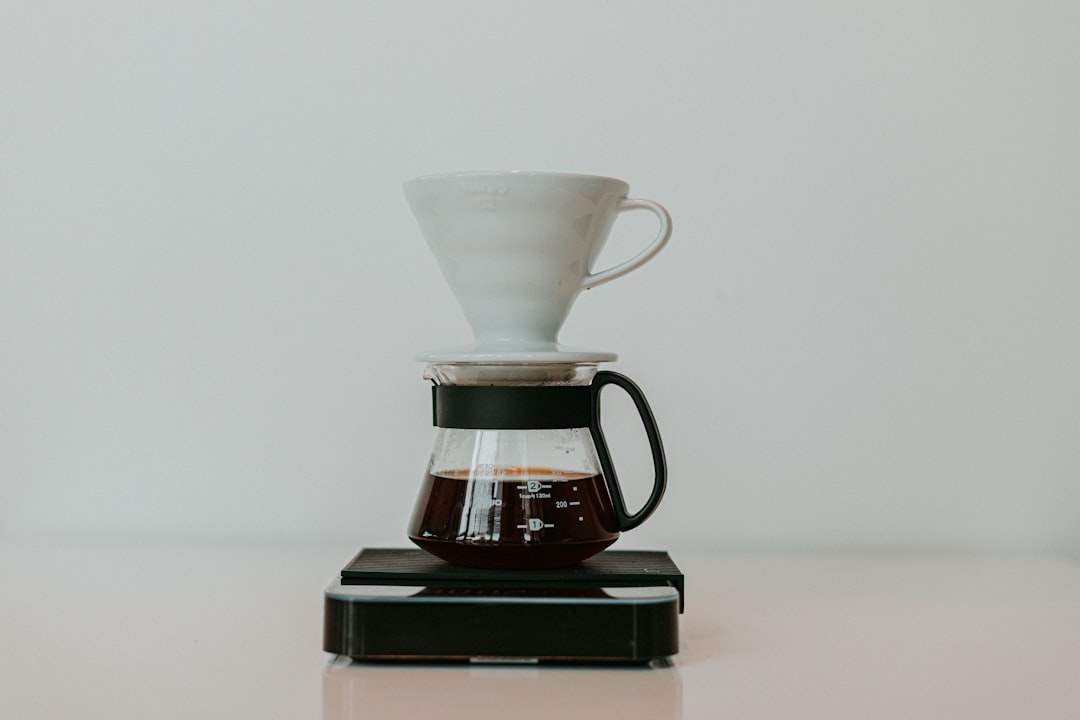 A compact travel coffee kit with brewing tools and accessories set up in a scenic outdoor location.