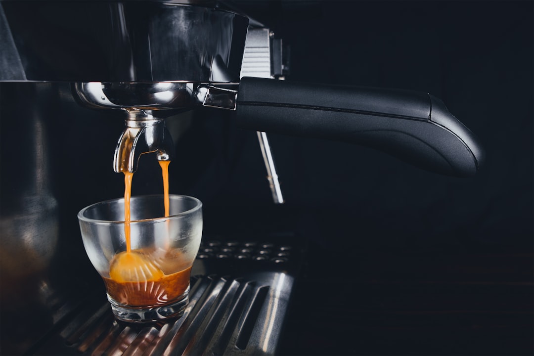 A collection of essential espresso accessories including a coffee scale, tamper, milk frother, and espresso machine parts on a wooden table.