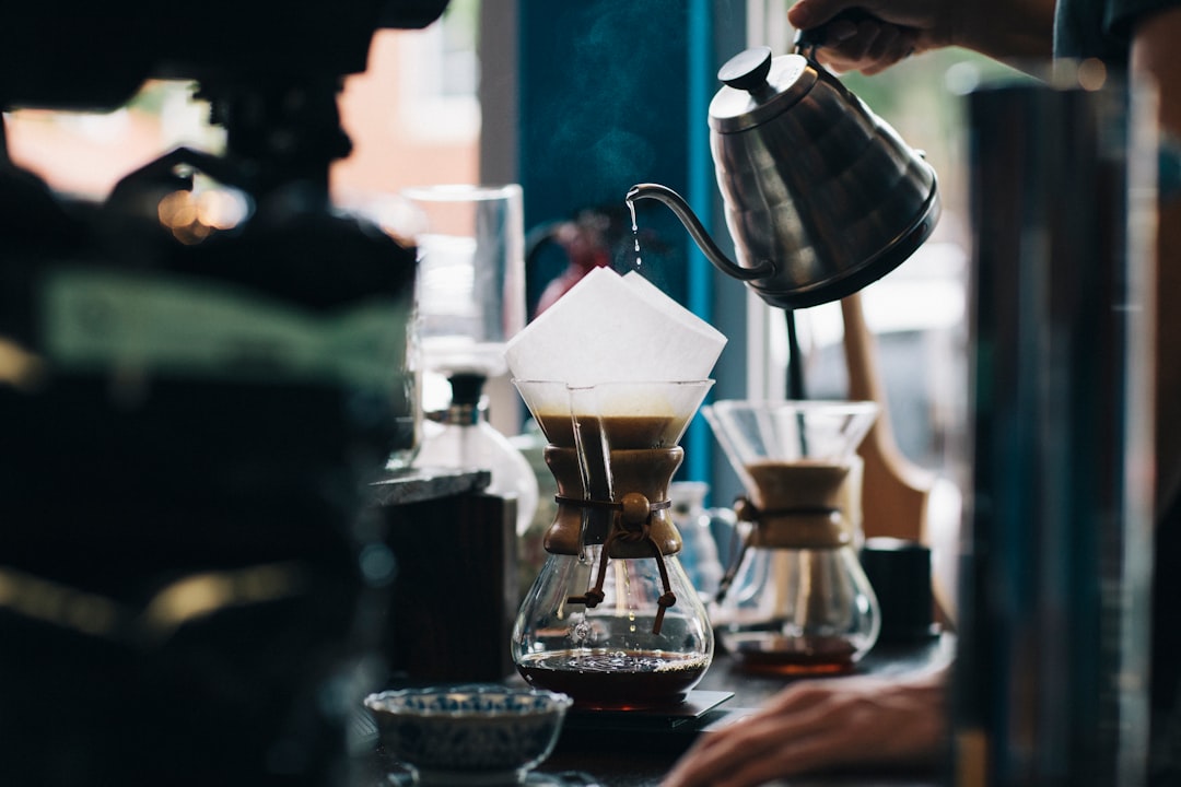 A cozy kitchen scene with a coffee maker, fresh coffee beans, and a steaming cup of coffee on the counter.